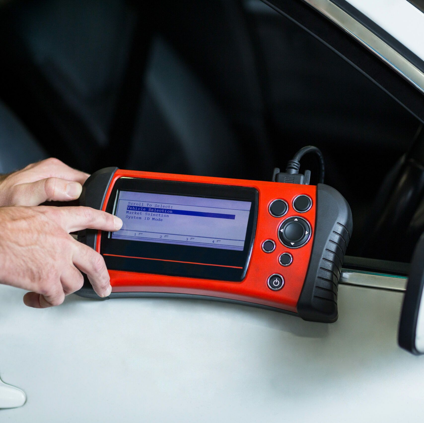 Hands of mechanic using a diagnostic tool in repair garage